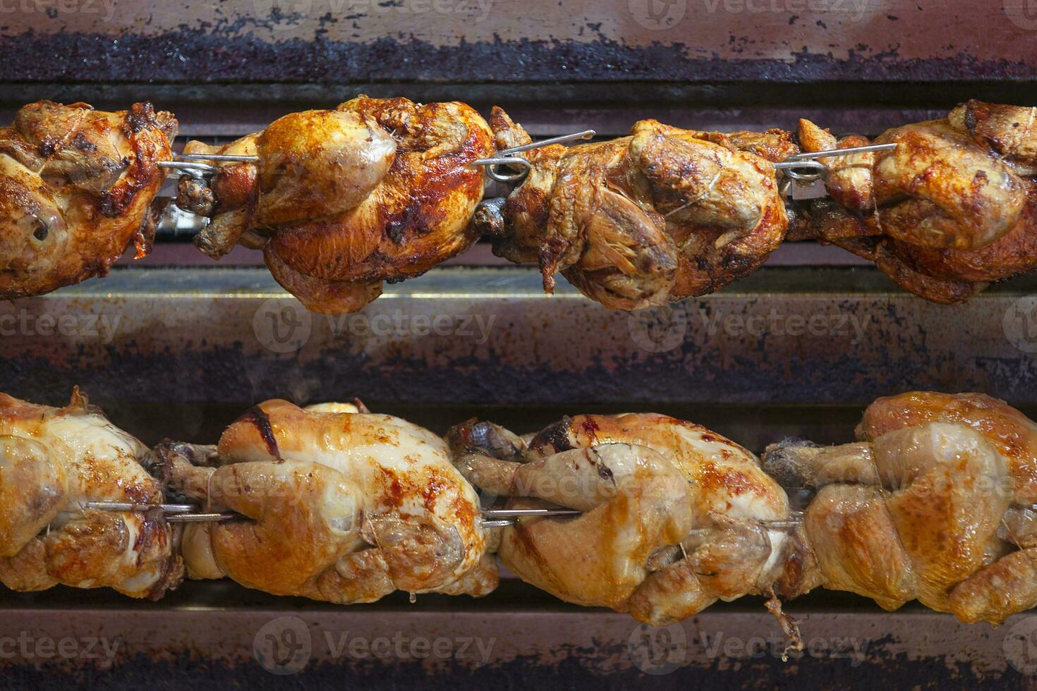 Two rows of chickens in a rotisserie photo