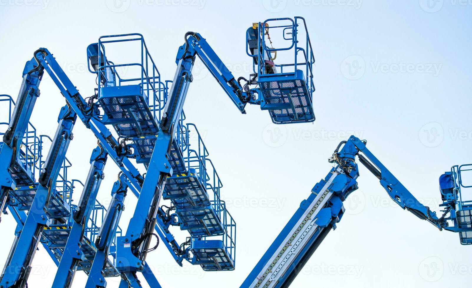 Articulated boom lift. Aerial platform lift. Telescopic boom lift against clear sky. Mobile construction crane for rent and sale. Maintenance and repair hydraulic boom lift service. Crane dealership. photo