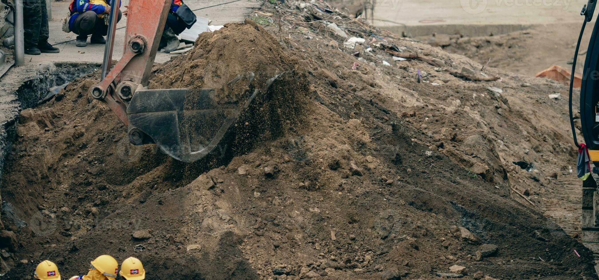 Backhoe working by digging soil at construction site. Bucket teeth of backhoe digging sand. Crawler excavator digging on soil. Excavating machine. Earthmoving machine. Excavation vehicle. Road repair. photo