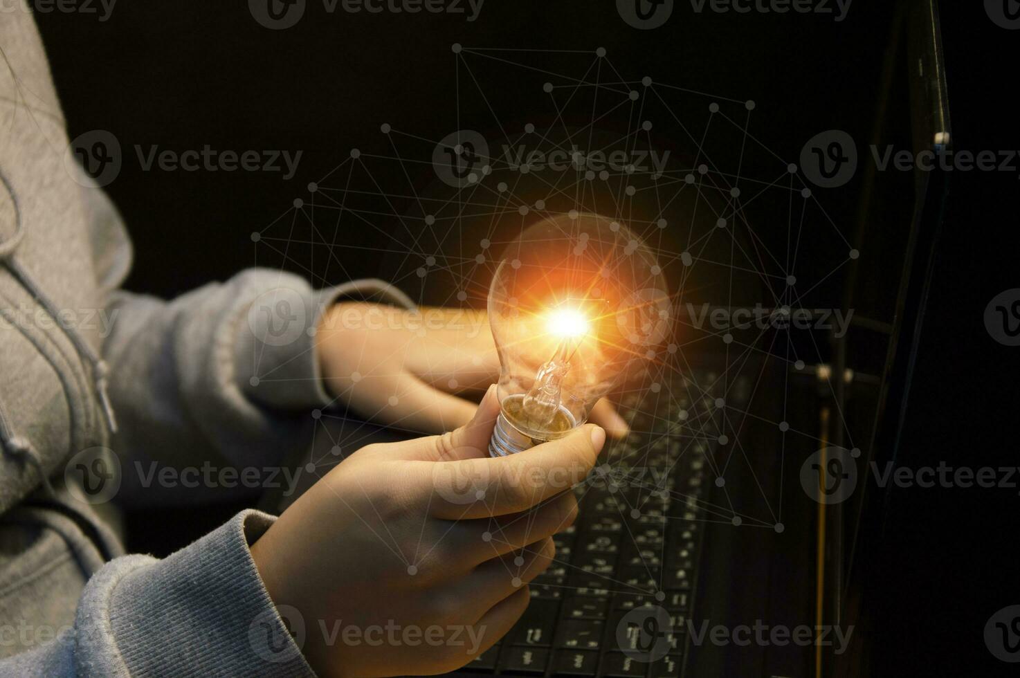 Close up of the hand of a person holding a bright light bulb in black background. Idea, innovation, idea and inspiration for business concept. cyber digital data concept photo