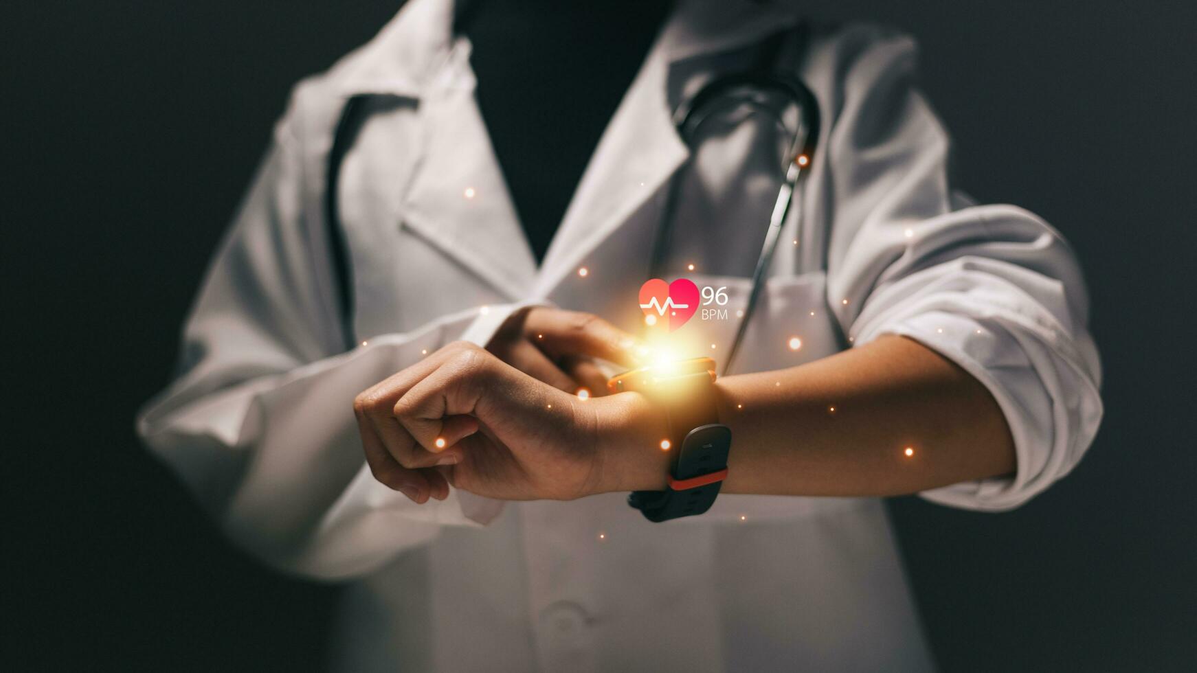 Close up of female doctor using smartwatch with heart icon on screen photo