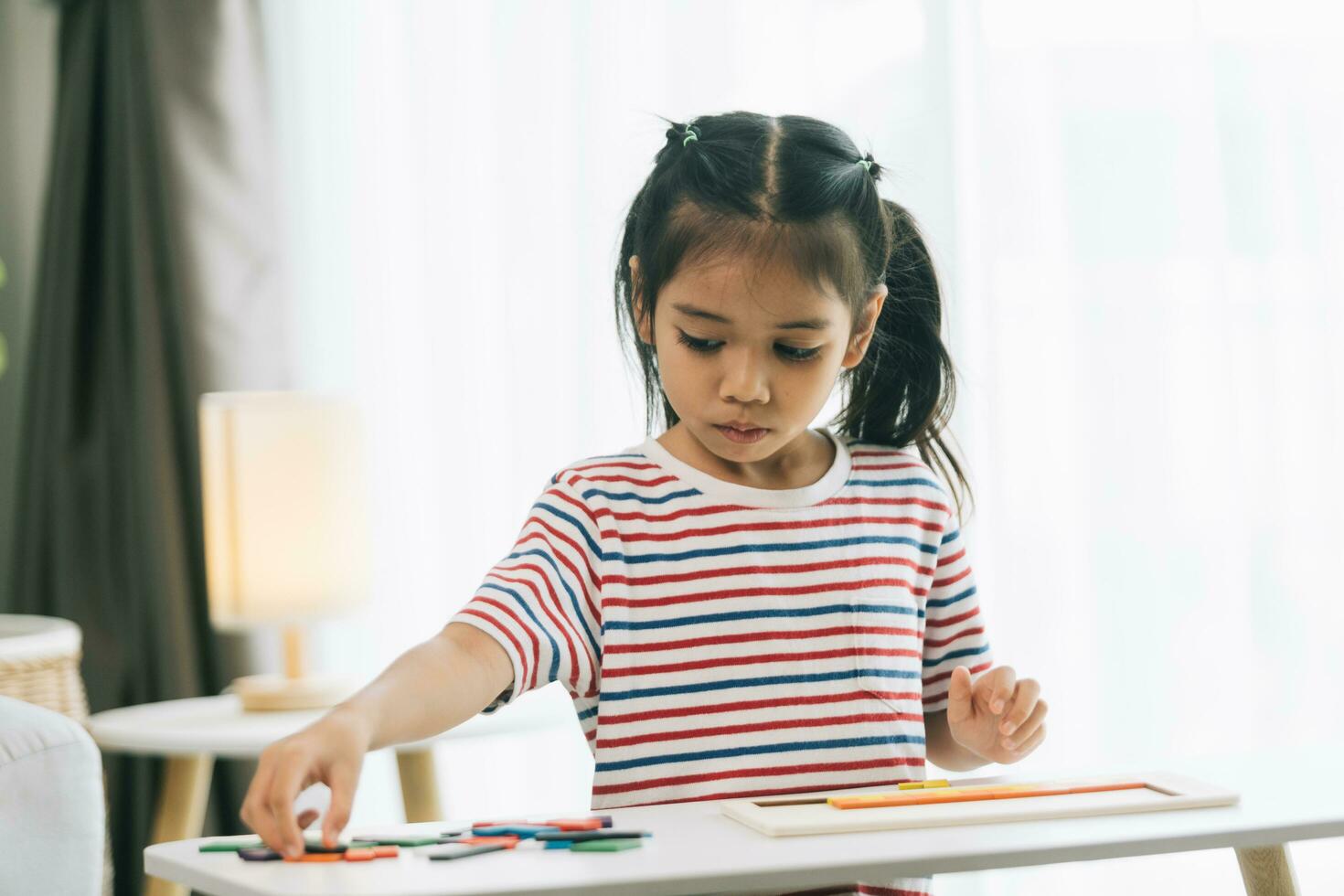 Asian little girl drawing with crayons in the living room at home photo