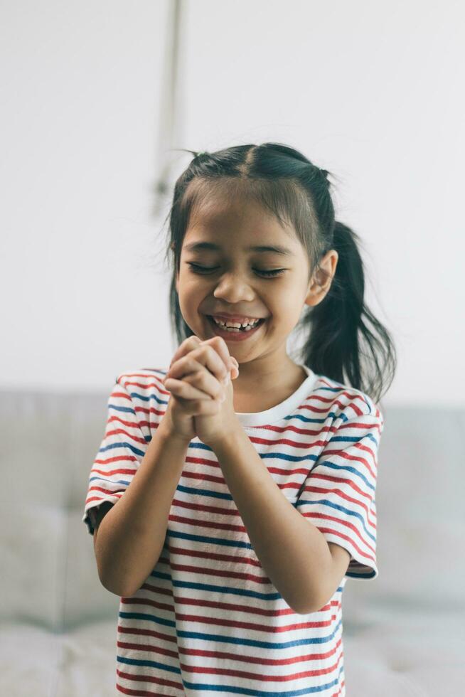 retrato de contento asiático pequeño niño niña sonriente y jugando a hogar foto