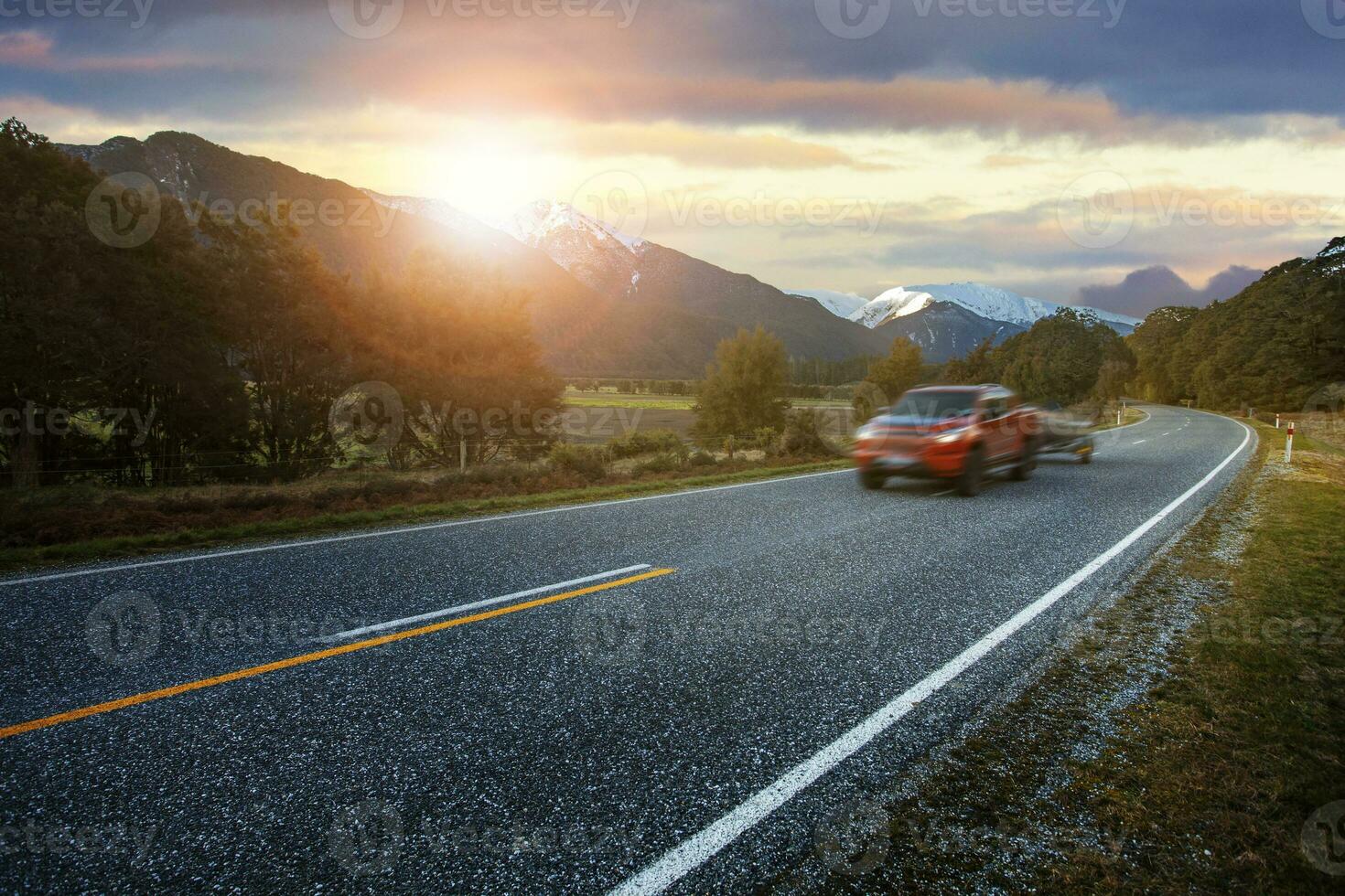 red pick up truck passing on asphalt highway at mount aspiring national park southland new zealand one of most popular traveling destination photo