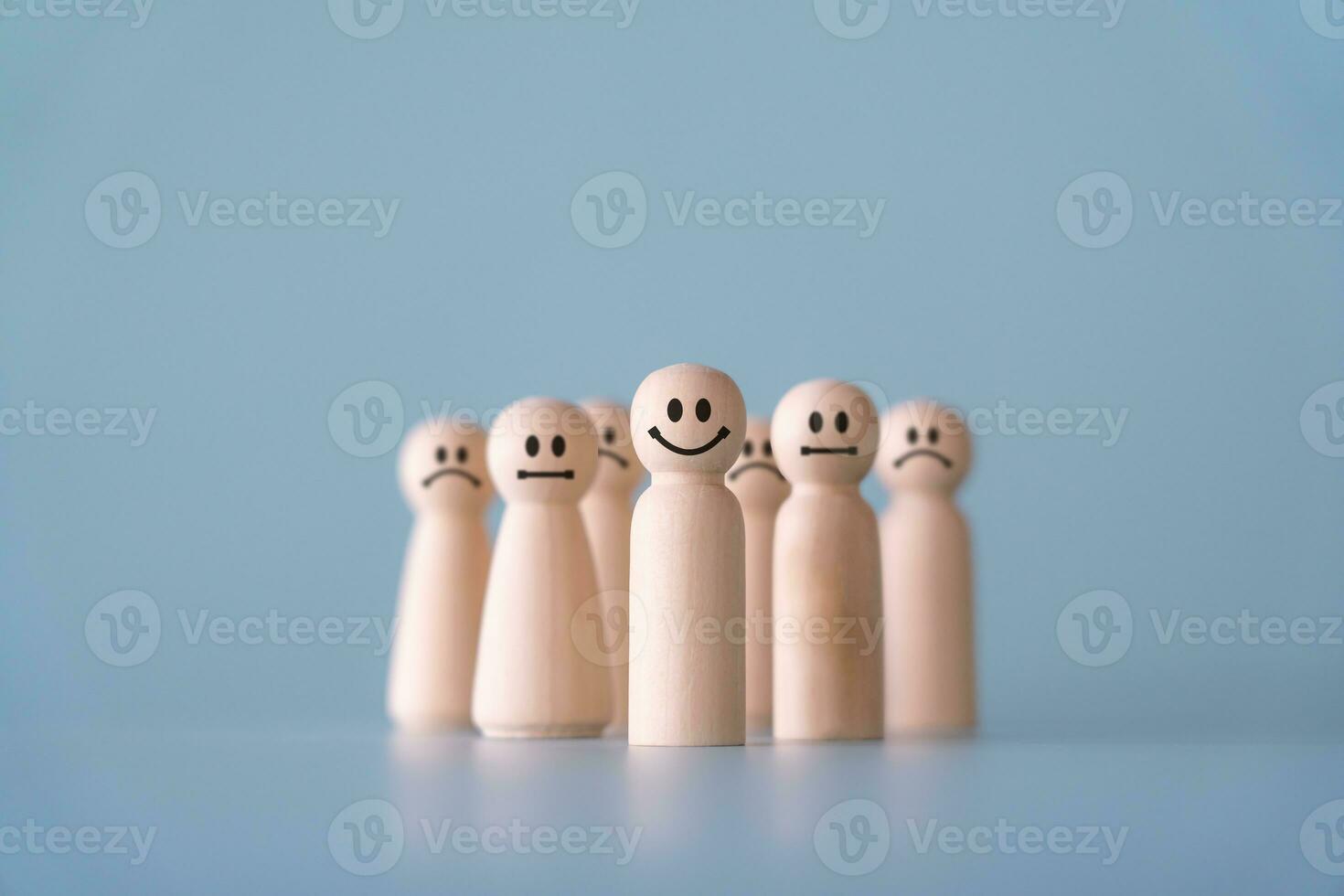 Group of wooden human figures standing in community society concept. Wooden dolls on light blue background. photo