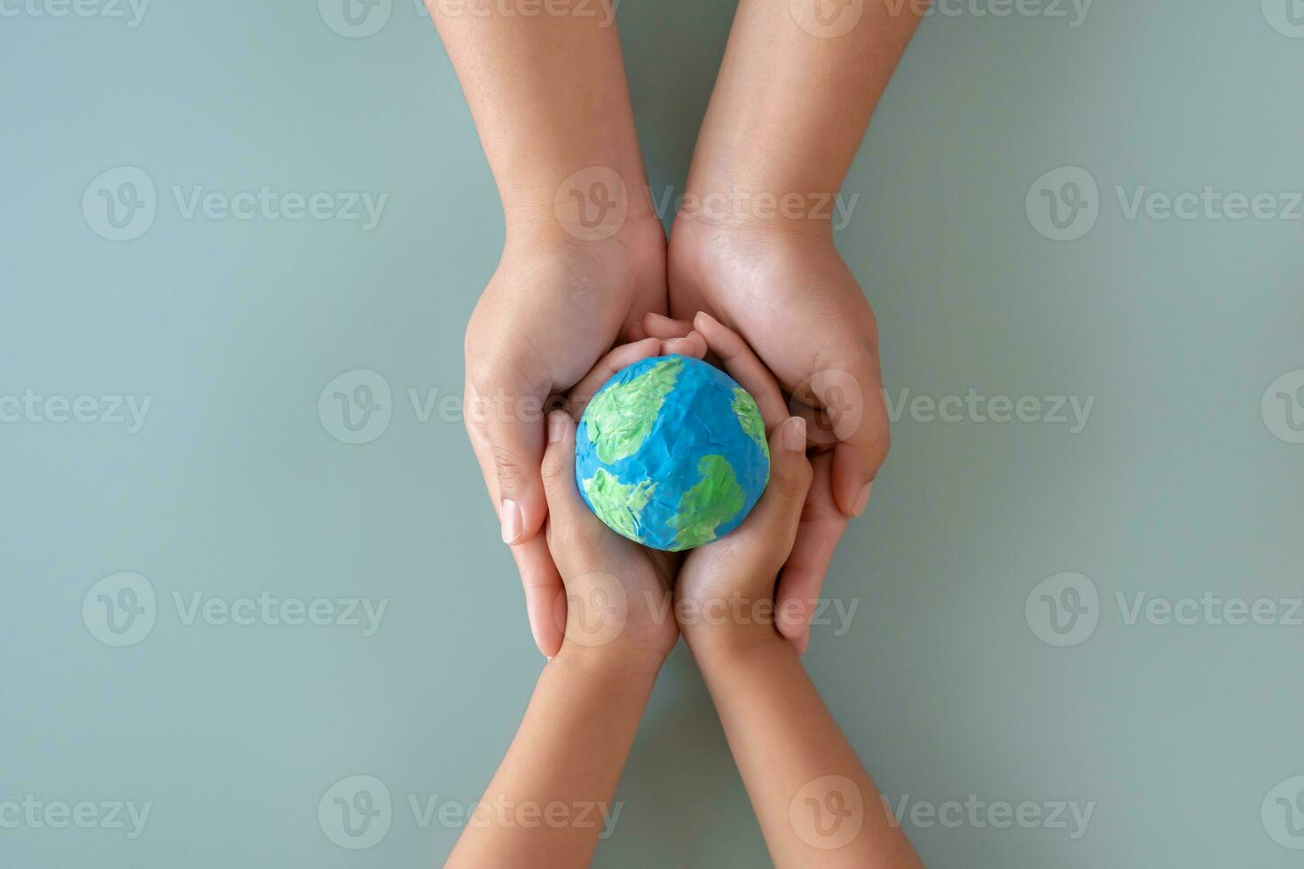 Hands holding earth paper and water paint. Concept of protecting the world from global warming. Sustainability topic to save the world. photo