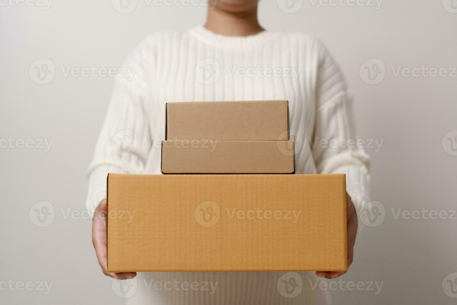 Woman hands holding present box with a ribbon bow. Concept of gift  box minimalist style. Showing brown cardboard boxes delivery someone in special occasions or parcel deliver service. photo