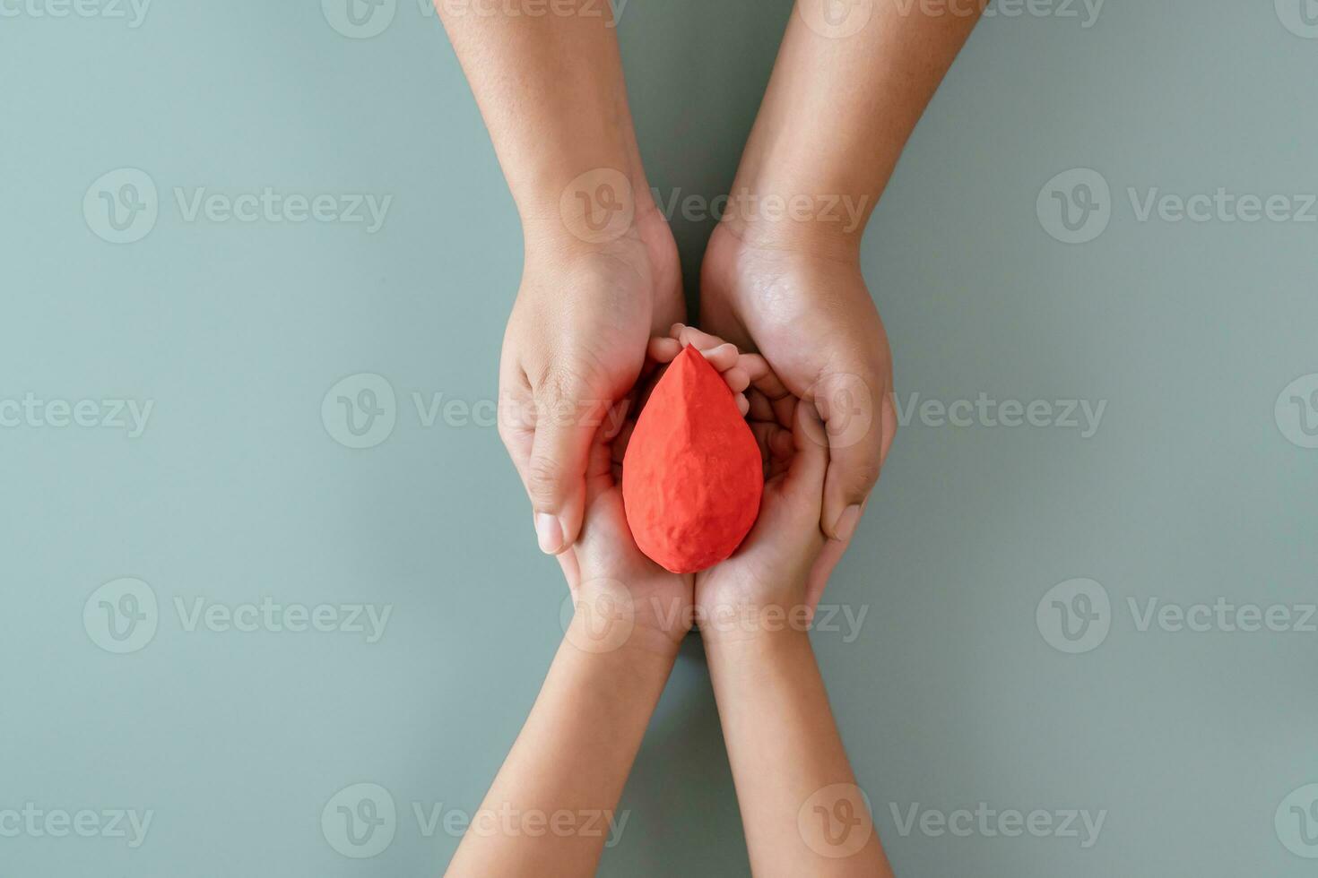 Blood donation or medical surgery concept. Human holding small piece of paper blood sign and a red heart shape. Give blood save up to three lives. photo