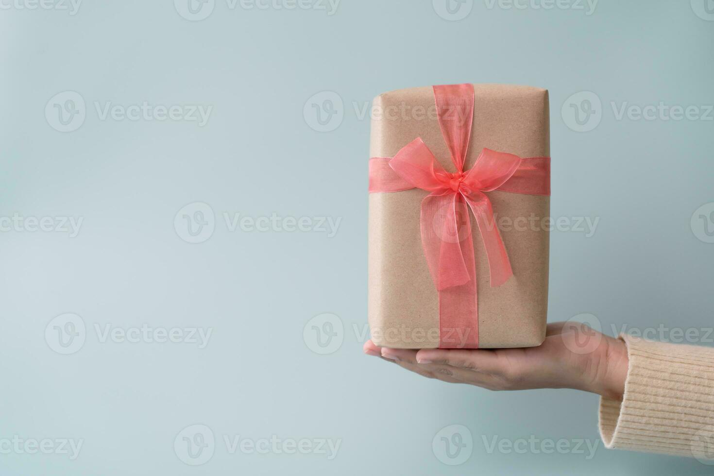 Woman carrying gift paper box tie cute ribbon for special occasion. Delivery sending present to someone special to thank or surprise. photo