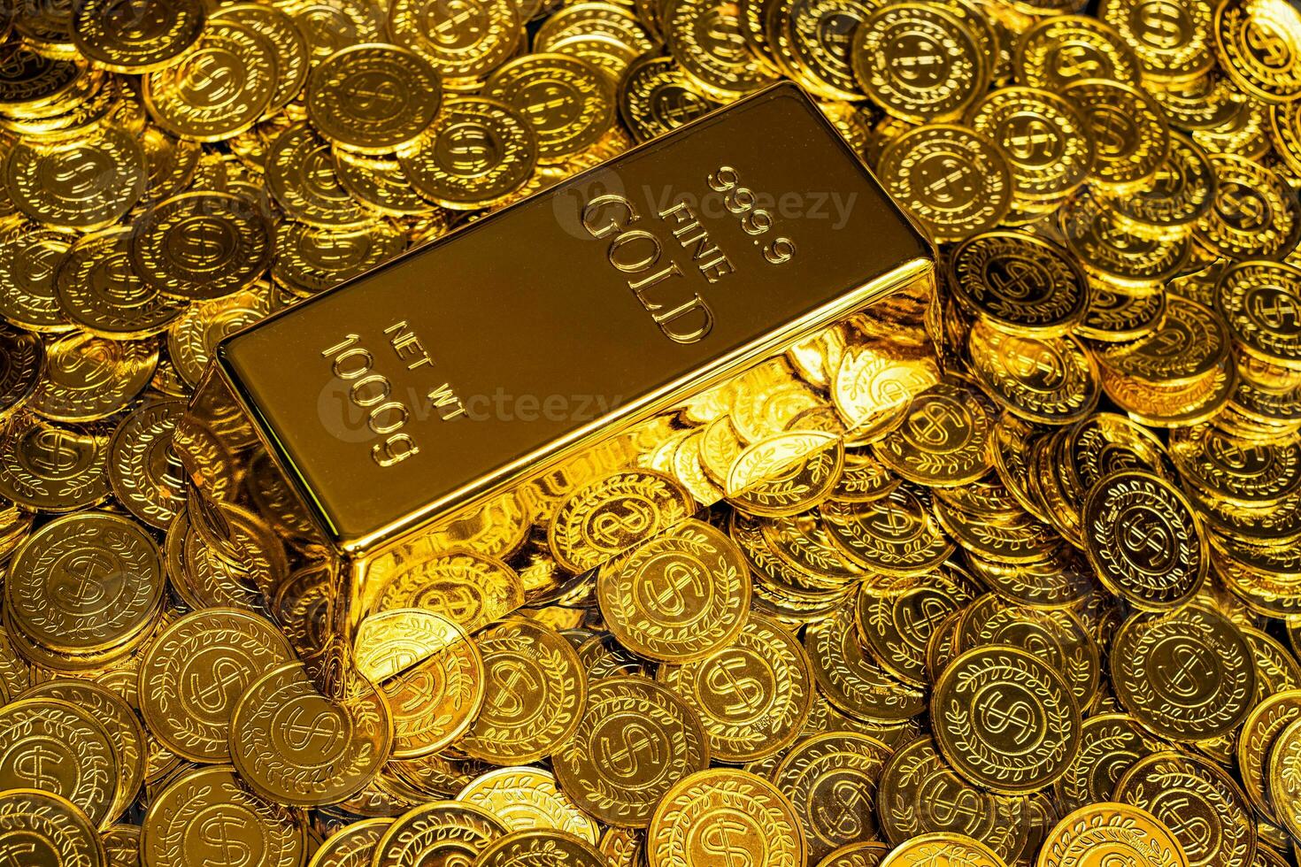Gold bars are placed on a pile of gold coins photo