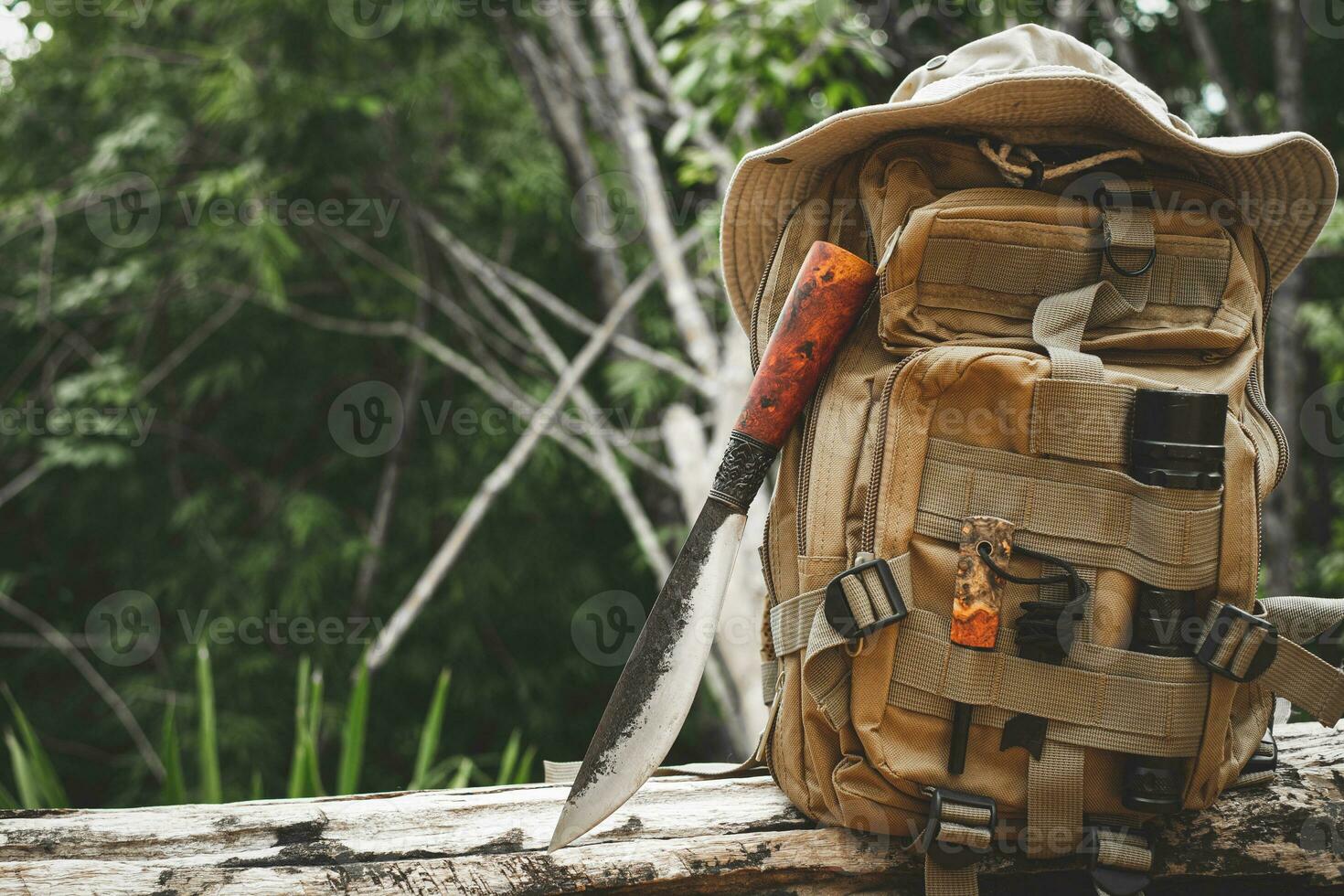 un cuchillo mochila con equipo para supervivencia en el bosque en un antiguo madera de madera foto