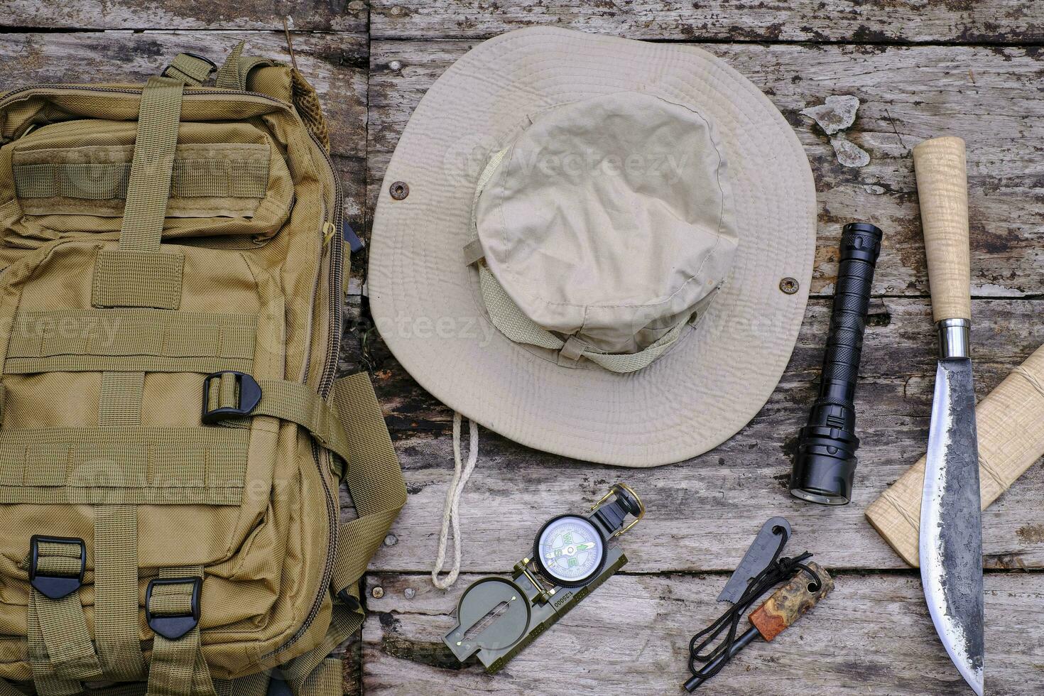 Knife backpack with equipment for survival in the forest on the old wooden background photo