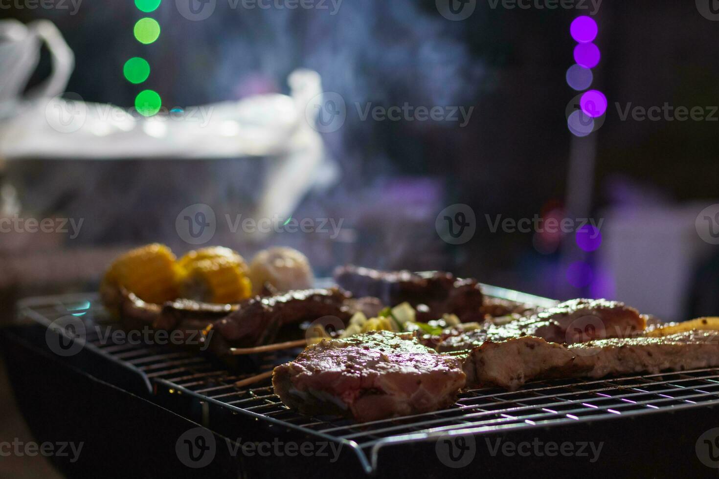 Meat and skewers ingredients for barbecue party are placed on grill to cook barbecue and make it ready for family to join barbecue party tonight.  party background image has Copy Space for text. photo