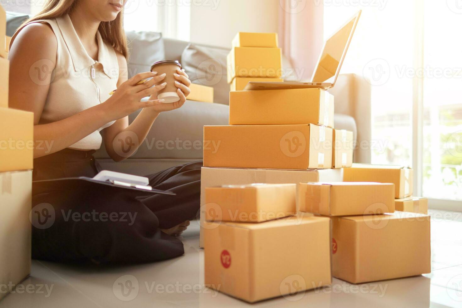 woman checking package of goods from customer online order is alone in her home office as she is an SME entrepreneur and uses her phone and tablet to market online. concept online sales business photo