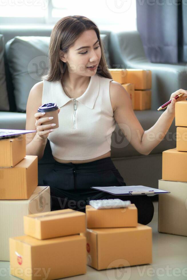 small sme entrepreneur is packing products into parcel boxes in preparation for transporting them to freight forwarder to deliver to customers with incoming orders. Concept Ecommerce Team online sales photo