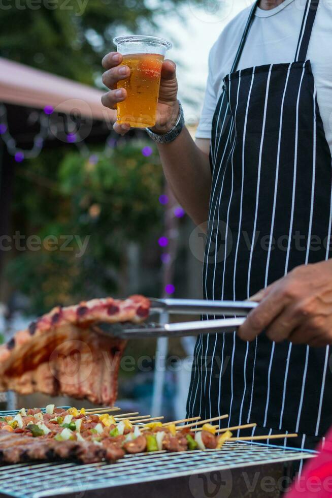 Beer drinks prepared for barbecue party among friends are served in plastic glasses because plastic glasses can be easily stored at end of party. Easy party idea by serving beer in plastic glasses. photo