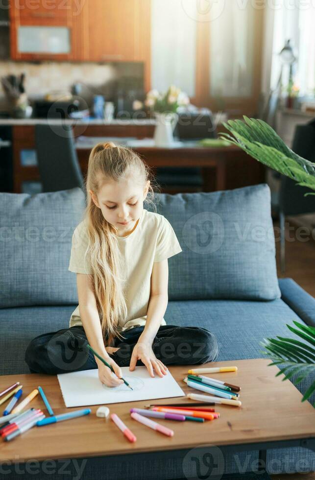 Child girl drawing with colorful pencils photo