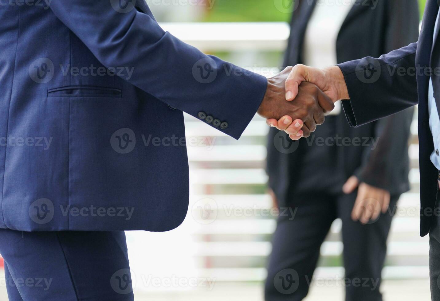 two business people shaking hands to greet each other photo
