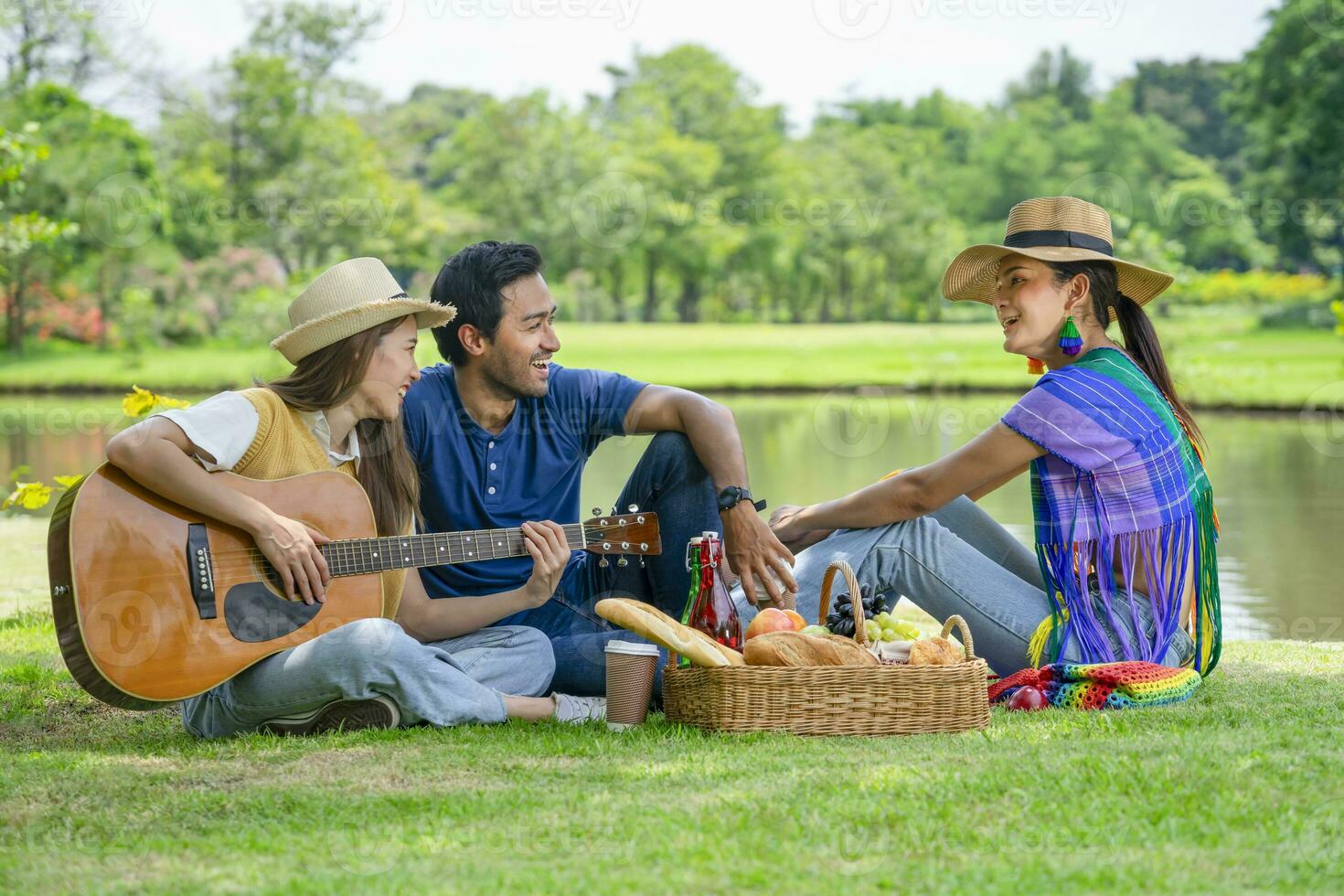 young diversity genders friends,man,woman and woman transgender enjoy leisure time in the park,having picnic,playing music take pleasure in nature,concept of people lifestyle,holiday,resting,relaxing photo