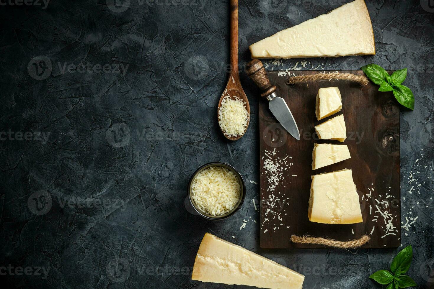 Top view of triangular piece of hard cheese on wooden cutting board photo