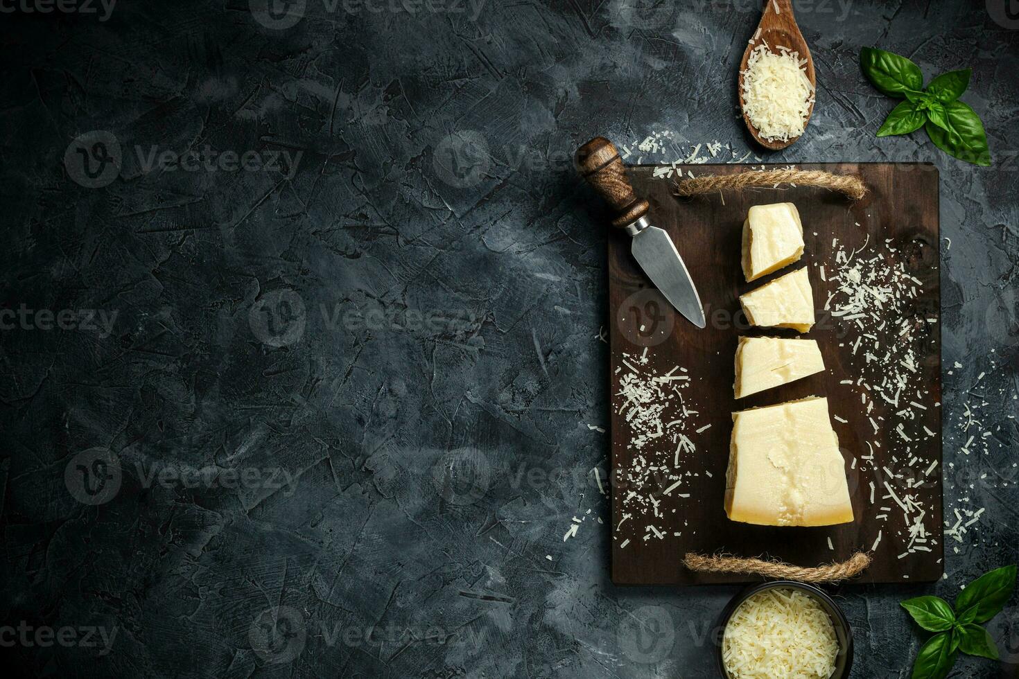 Top view of triangular piece of hard cheese on wooden cutting board photo