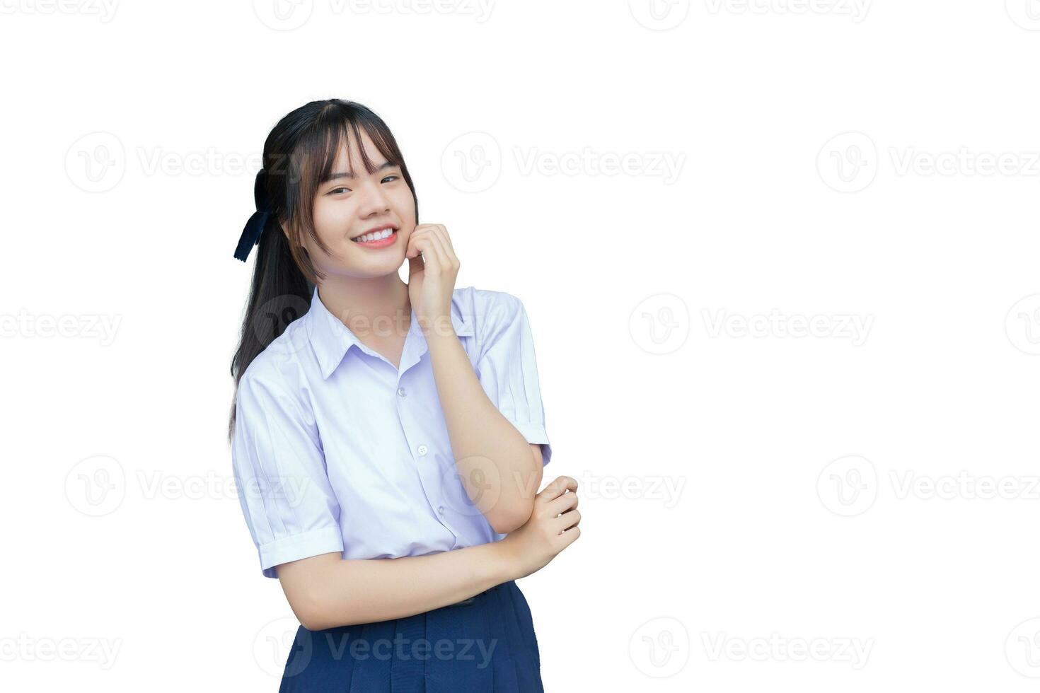 Beautiful young Asian high school student girl in the school uniform with smiles confidently while she looks at the camera happily while isolated on white background. photo