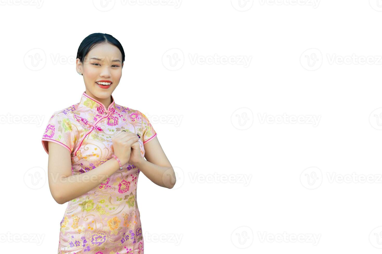 hermosa asiático mujer con largo pelo quien usa rosado cheongsam vestir en chino nuevo año tema mientras ella muestra su mano como chino saludo con en blanco antecedentes. foto