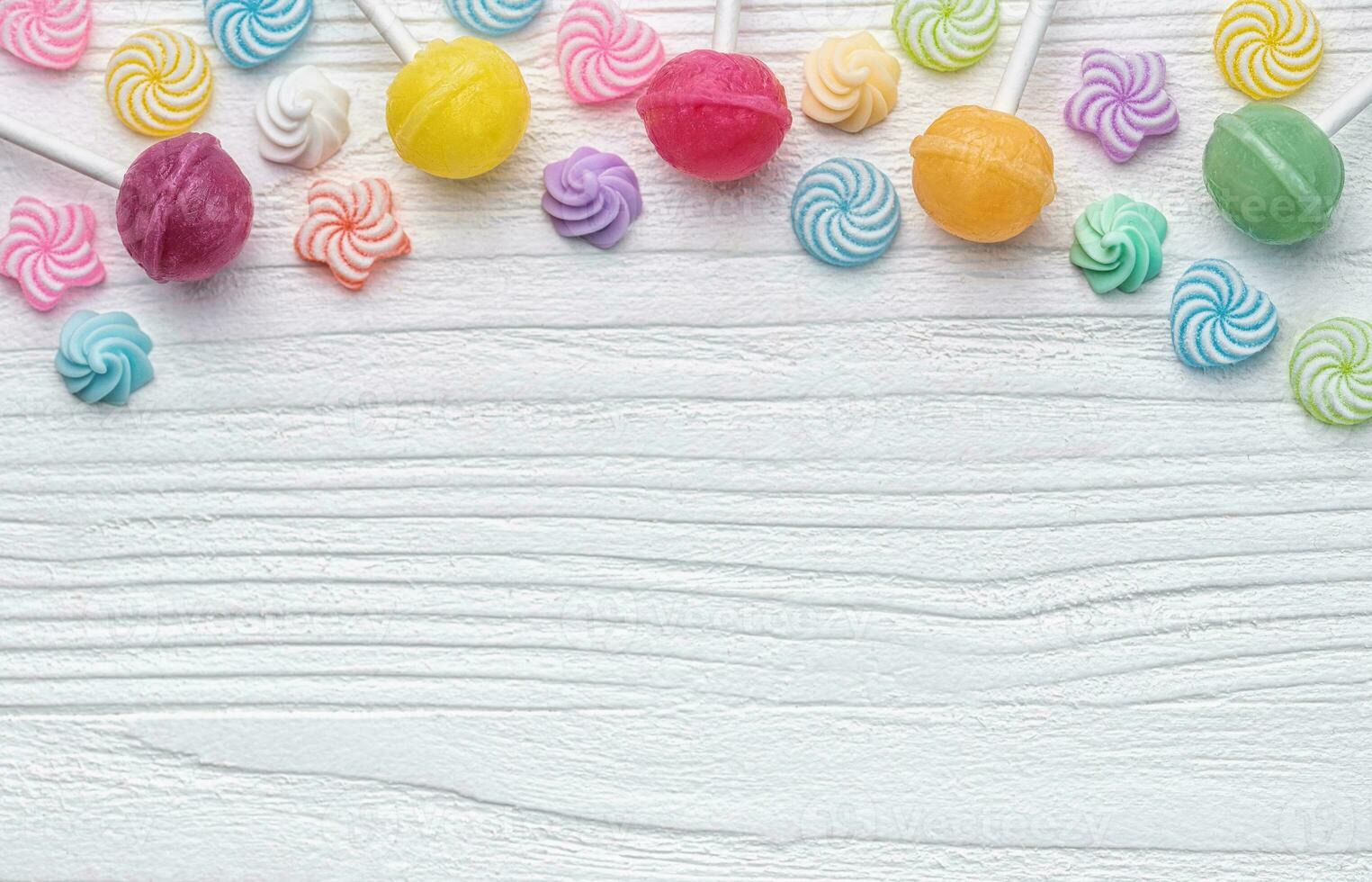 Sweet lollipops and candies on white wooden background photo