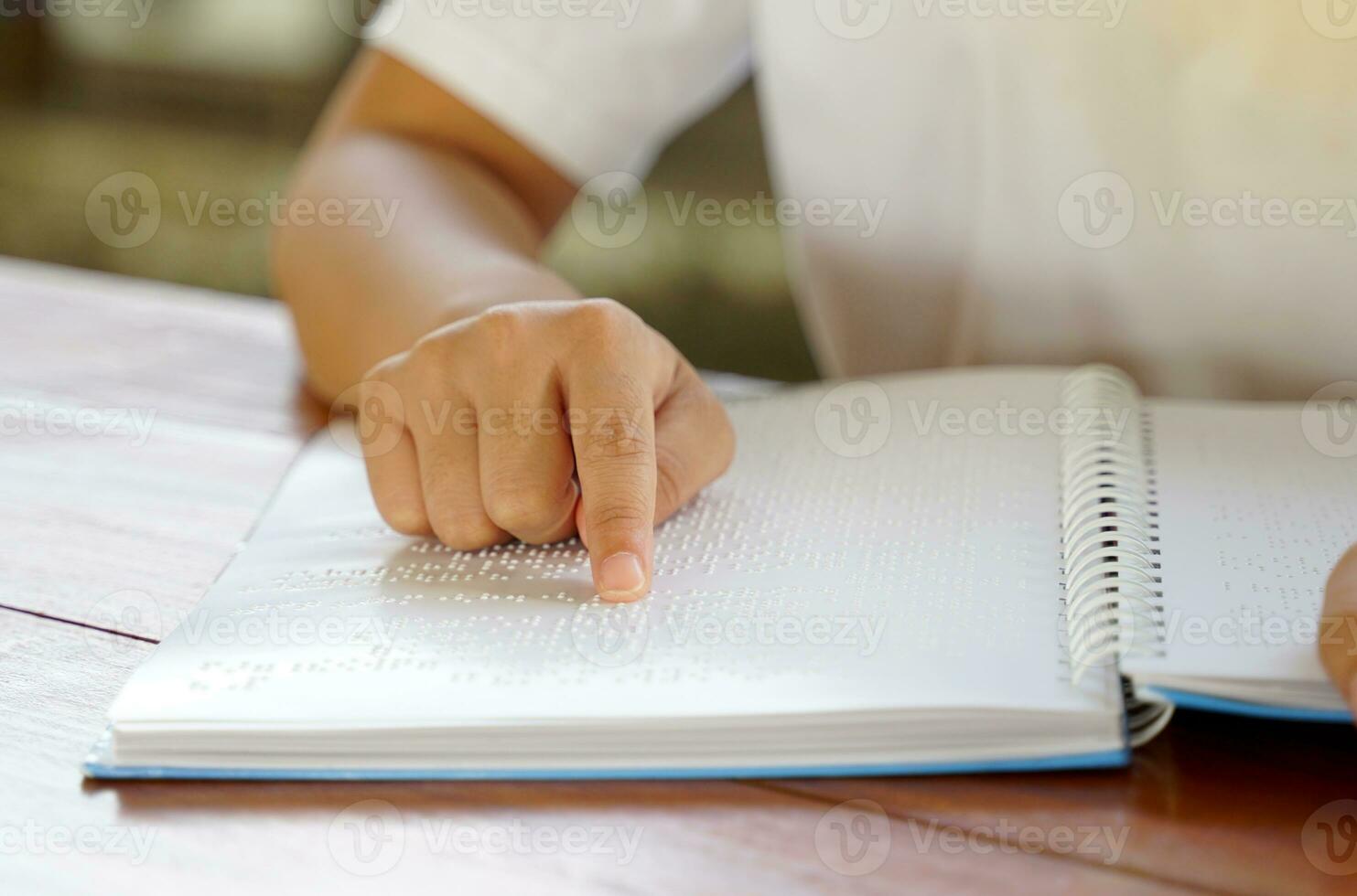 Visually impaired person reads with his fingers a book written in braille It is written for those who are visually impaired or blind. It is a special code generated from 6 dots in the box. photo