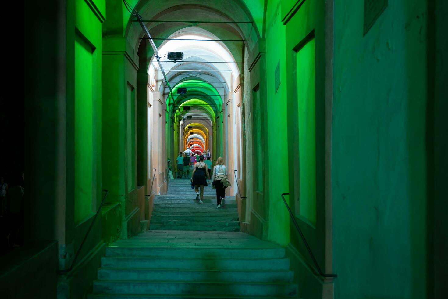 Bologna,Italy- June 23, 2023-People stroll at night under the arcades leading to the sanctuary of San Luca illuminated for the first edition of the Bologna arcades Festival. photo