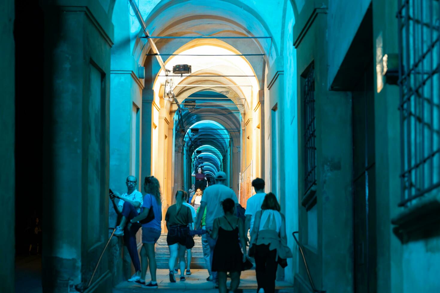 Bologna,Italy- June 23, 2023-People stroll at night under the arcades leading to the sanctuary of San Luca illuminated for the first edition of the Bologna arcades Festival. photo