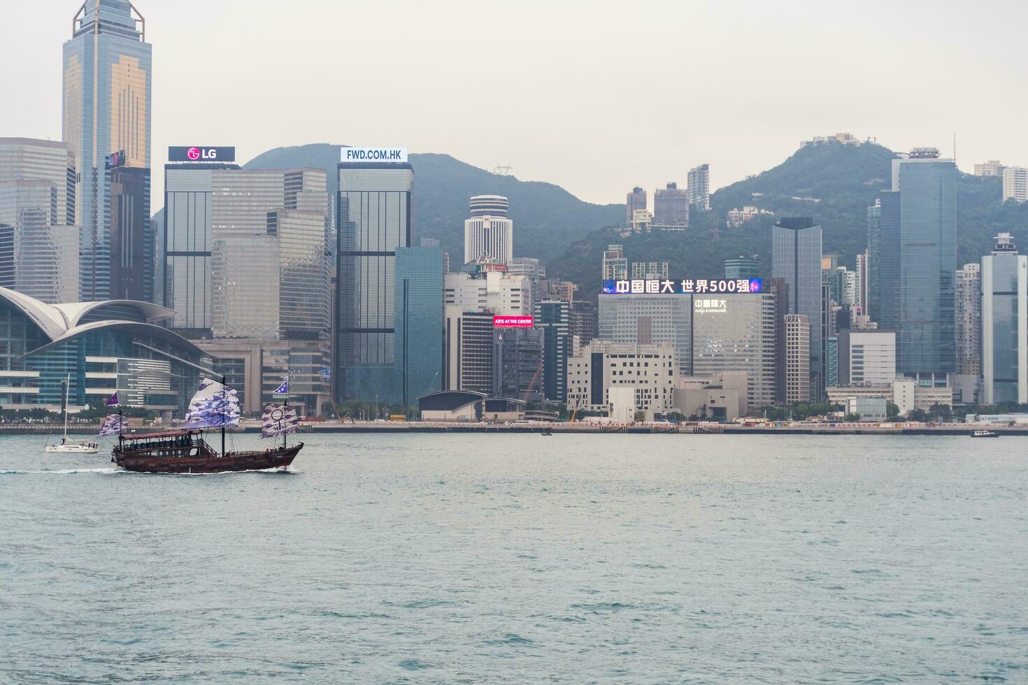 Hong Kong,March 25,2019-View of the Hong Kong skyscrapers and traditional boat from the Avenue of star on  the Victoria Harbour during a cloudy day photo