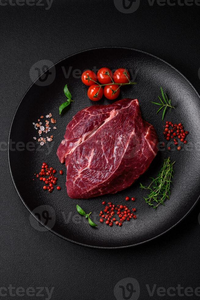 Fresh raw beef steak with salt, spices and herbs photo