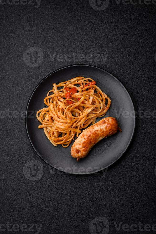 Delicious juicy grilled sausage with pasta or noodles with salt, spices and herbs photo