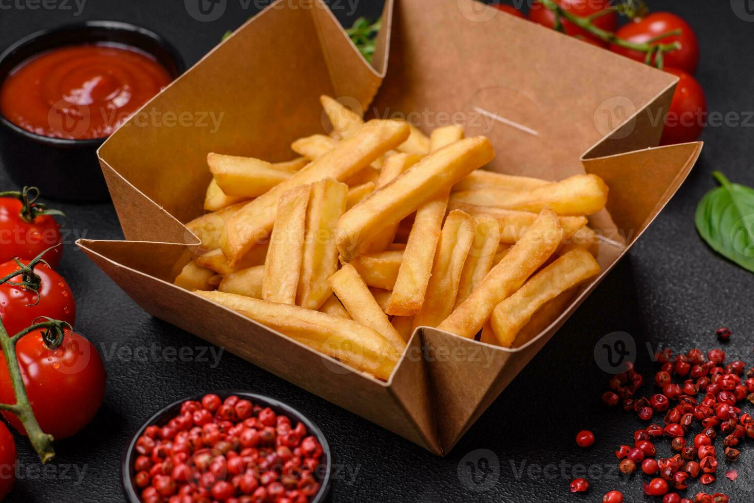 Delicious crispy french fries with salt and spices in a cardboard box photo