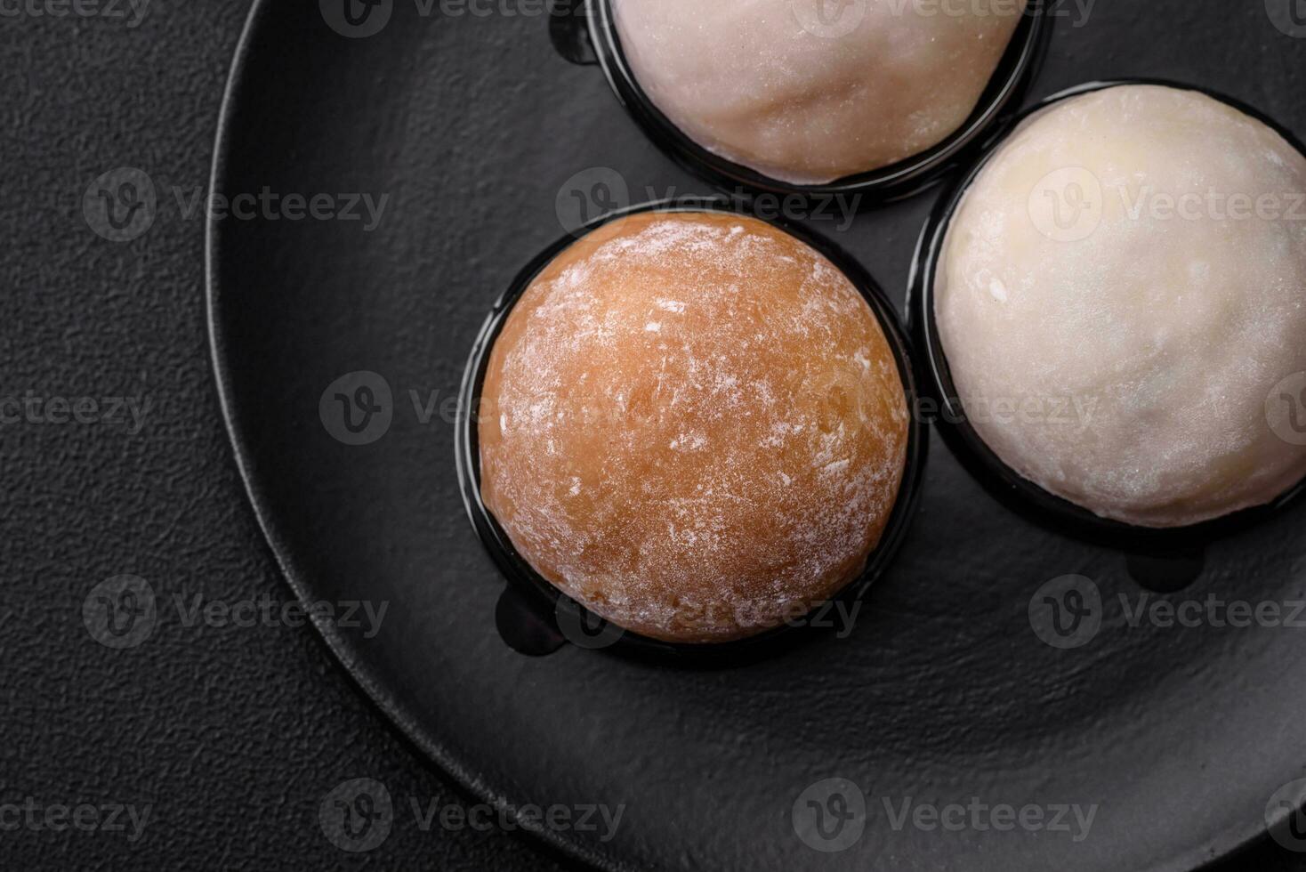 Delicious sweet mochi dessert with toppings on a dark concrete background photo