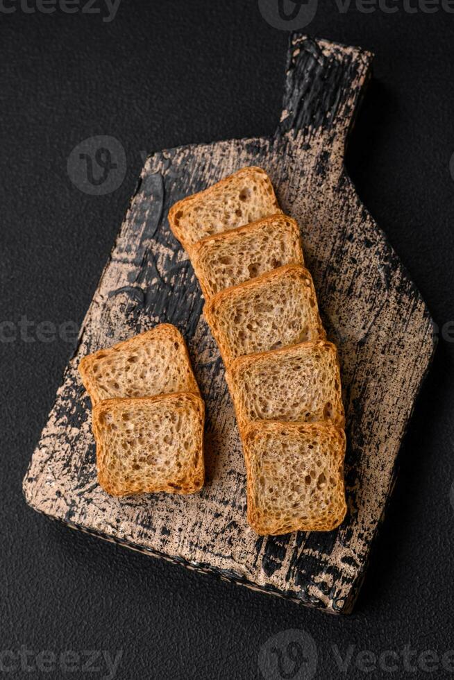 Delicious salted rectangular wheat croutons with salt and spices photo