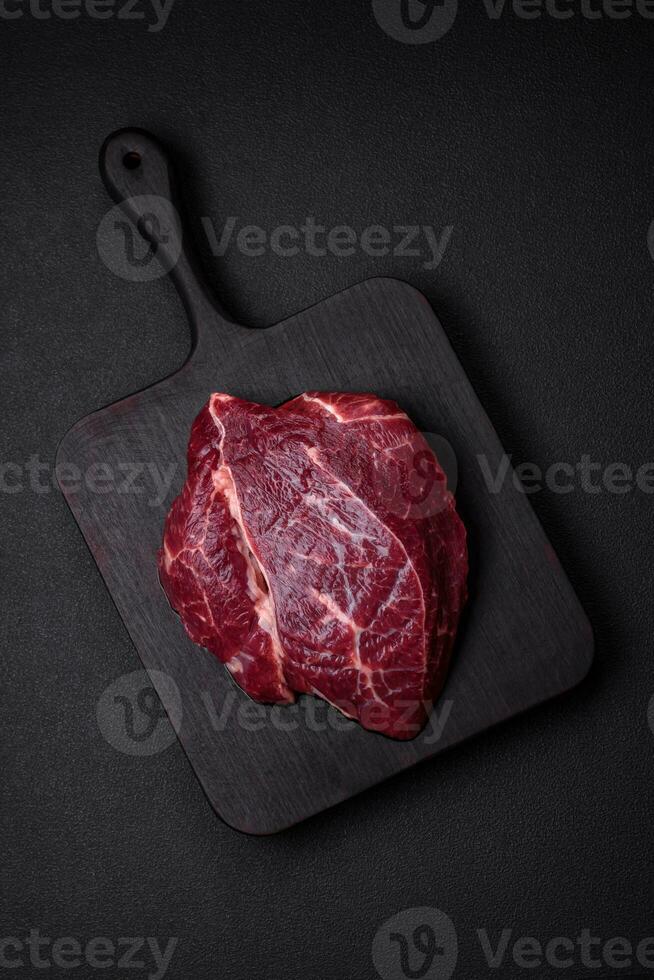 Fresh raw beef steak with salt, spices and herbs photo