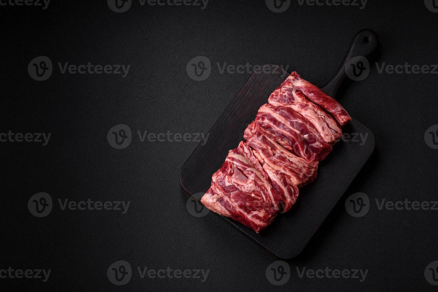 Fresh raw beef ribs with salt, spices and herbs photo