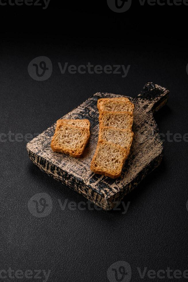 Delicious salted rectangular wheat croutons with salt and spices photo