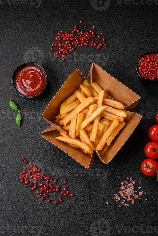 Delicious crispy french fries with salt and spices in a cardboard box photo