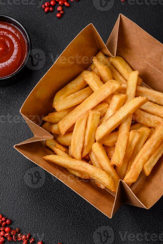 Delicious crispy french fries with salt and spices in a cardboard box photo