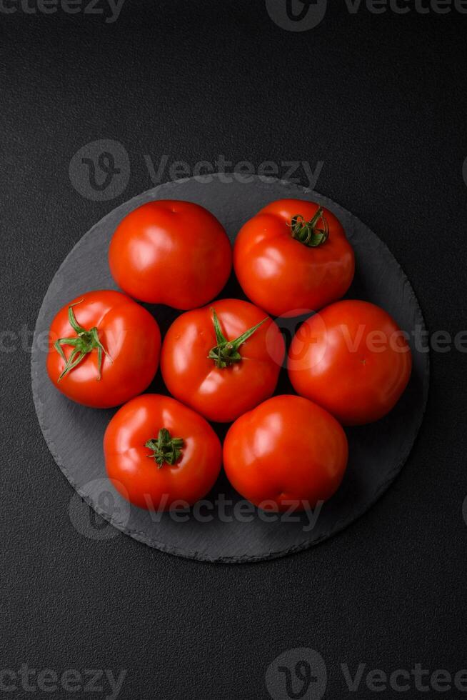 delicioso Fresco jugoso Tomates en un oscuro hormigón antecedentes foto