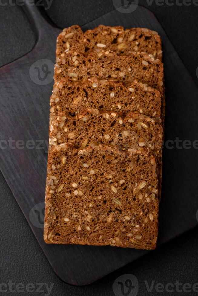 Delicious fresh crispy brown bread with seeds and grains cut into slices photo