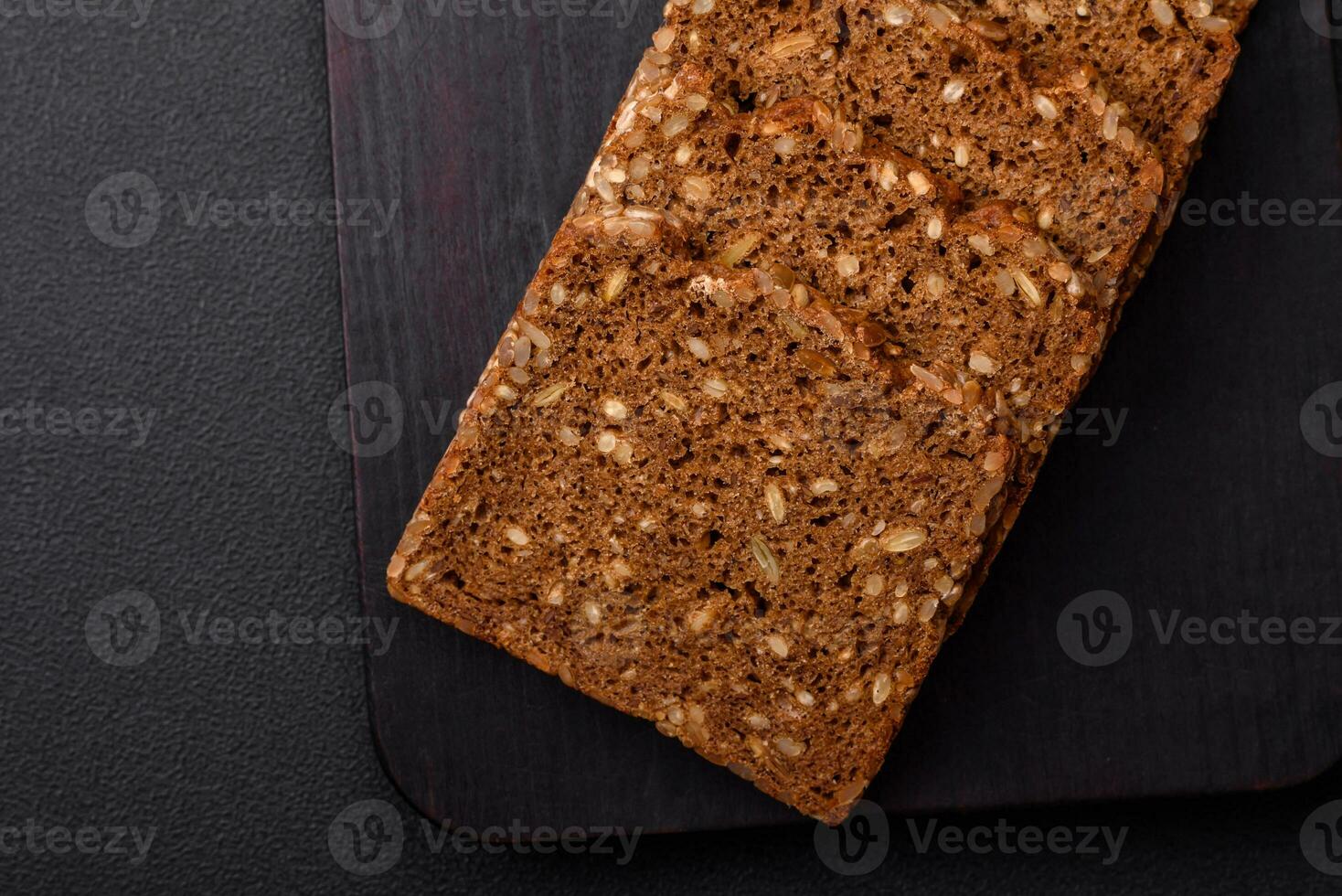 Delicious fresh crispy brown bread with seeds and grains cut into slices photo