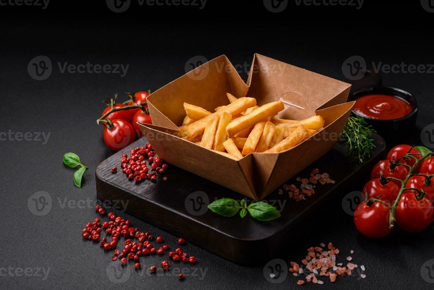 Delicious crispy french fries with salt and spices in a cardboard box photo