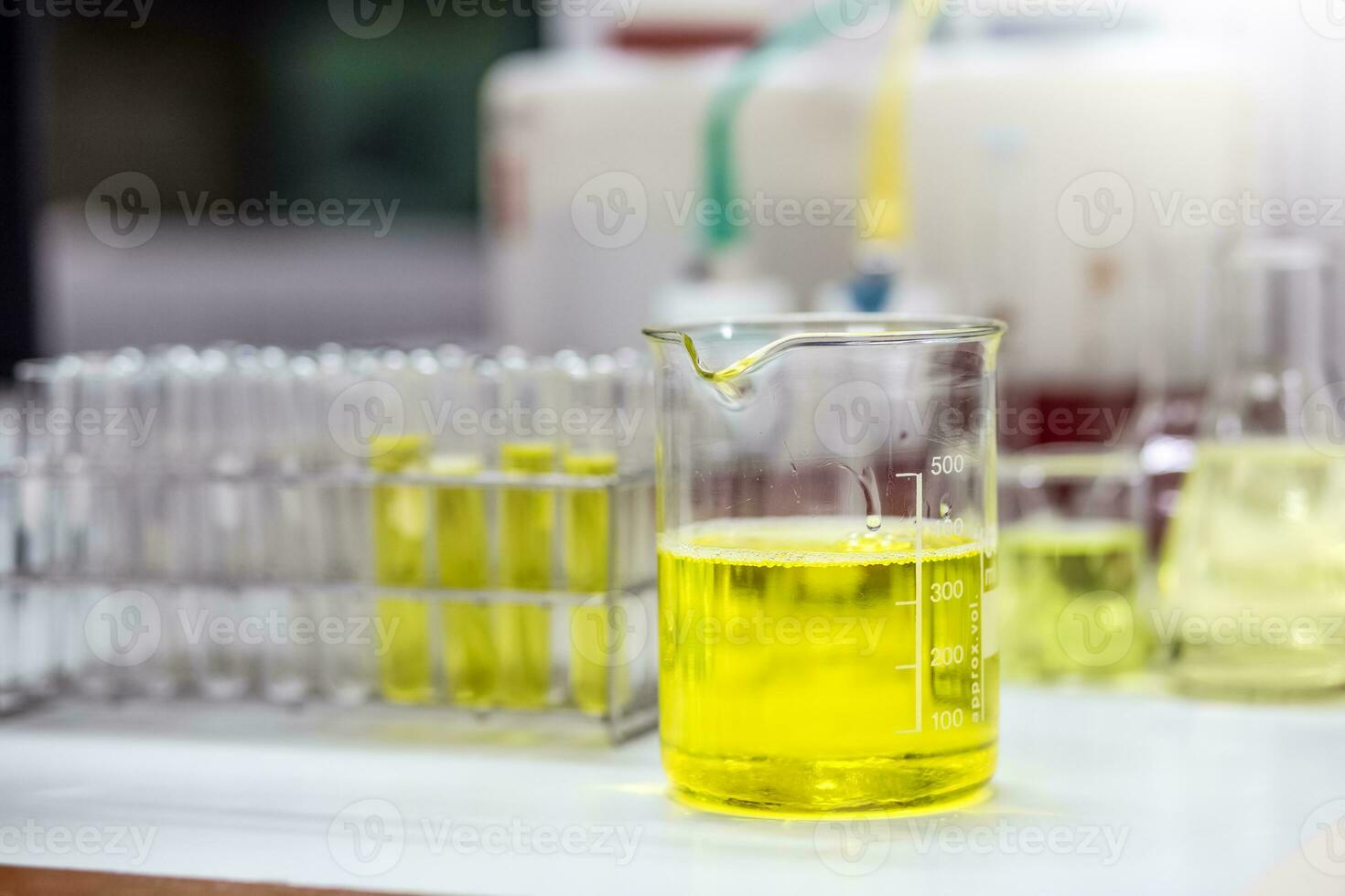 Pale yellow solution of an emulsifier a beaker for formulation test of the cosmetic product in the laboratory or industry. Research and Development cosmetics. photo