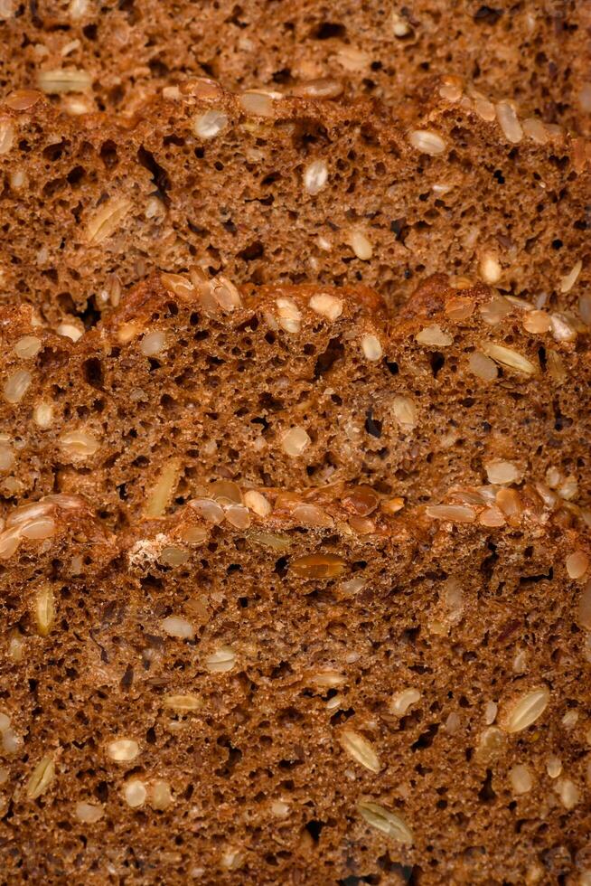 Delicious fresh crispy brown bread with seeds and grains cut into slices photo