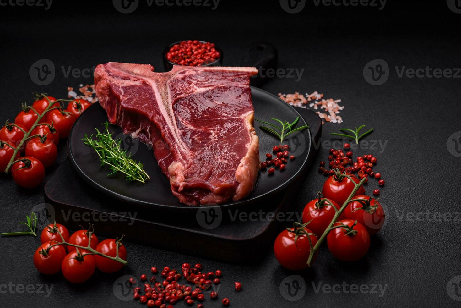 Raw juicy beef t-bone steak with salt, spices and herbs photo