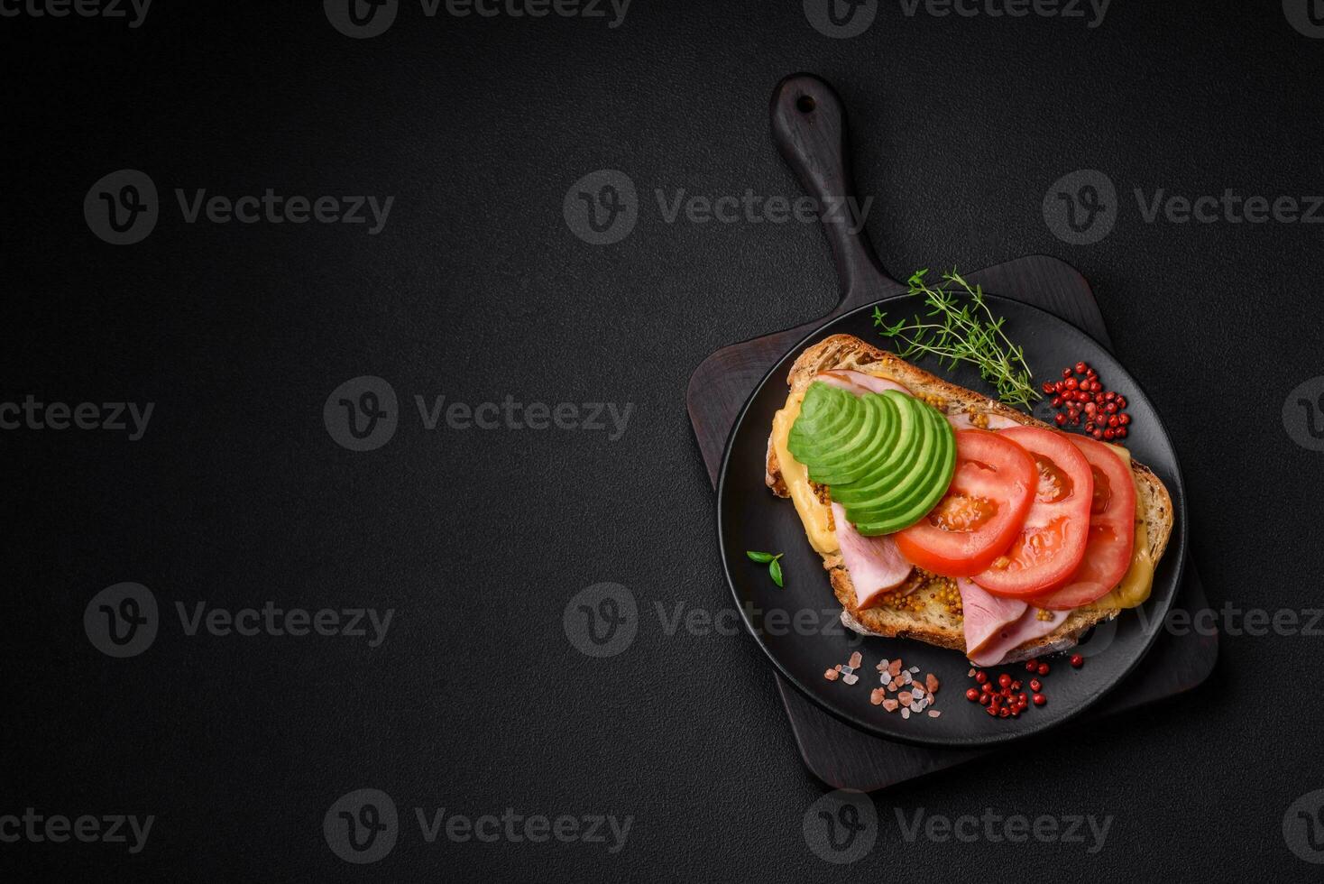 Delicious nutritious grilled toast with ham, cheese, tomatoes and avocado photo